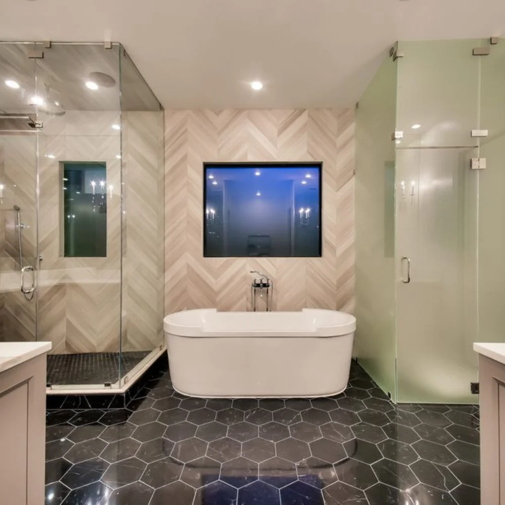 Freestanding bathtub between a glass shower and frosted enclosure in Long Beach bathroom