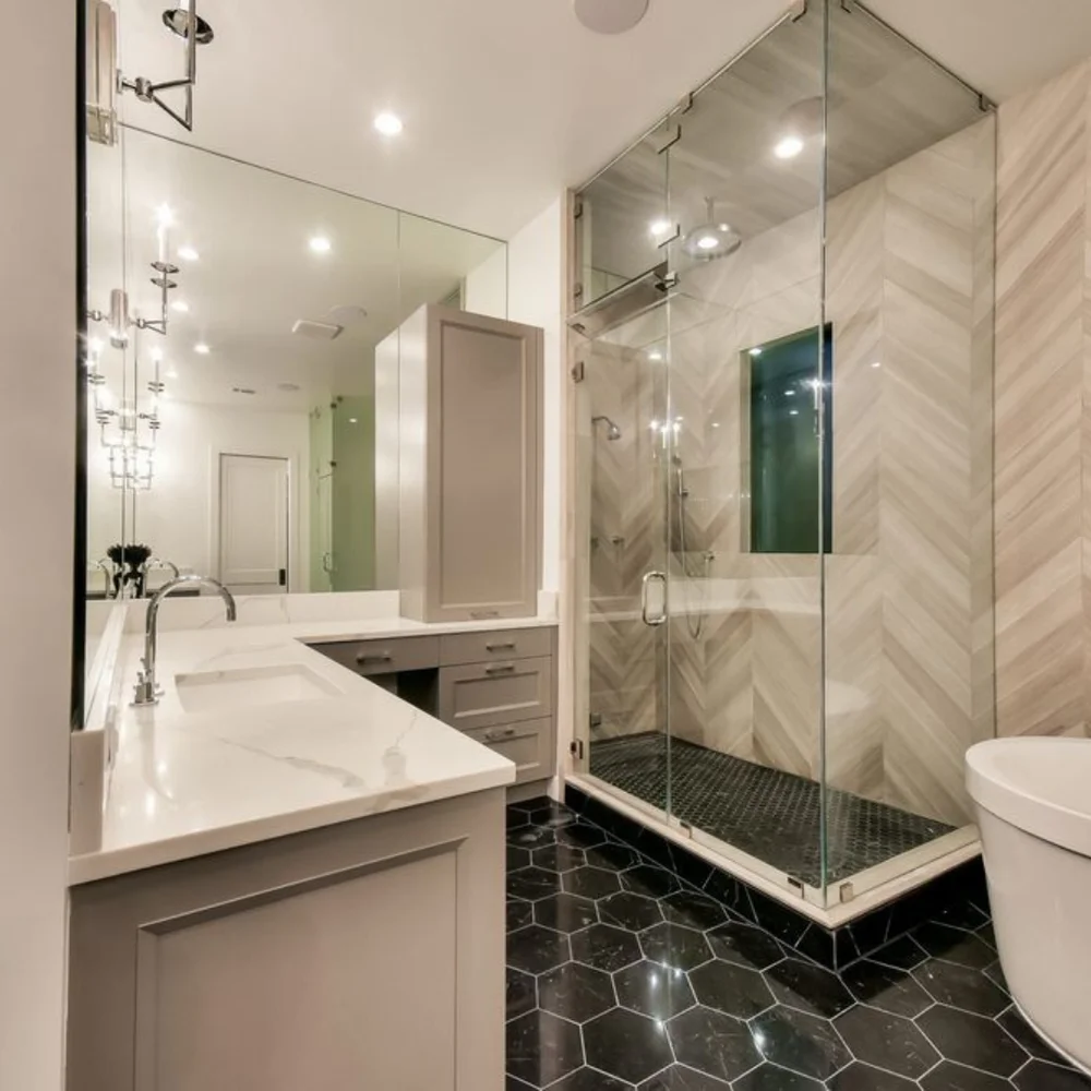 Long Beach bathroom showing the vanity, glass shower and dark hexagonal floor tile