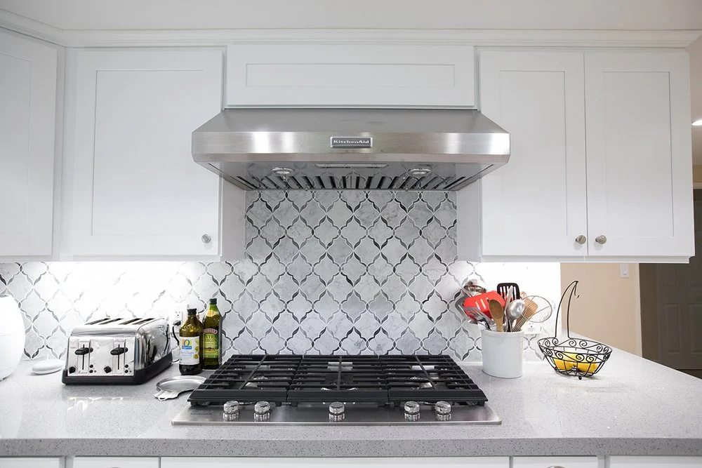 Cooktop, range hood and white cabinetry in a KM Builders Woodland Hills kitchen remodel